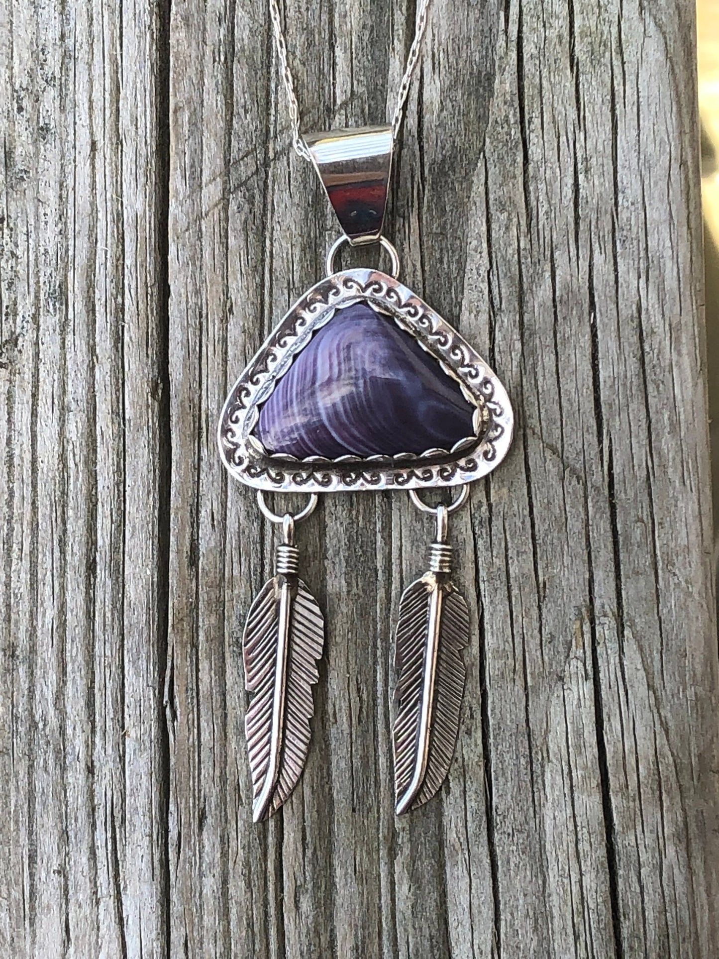 Wampum pendant with feathers.