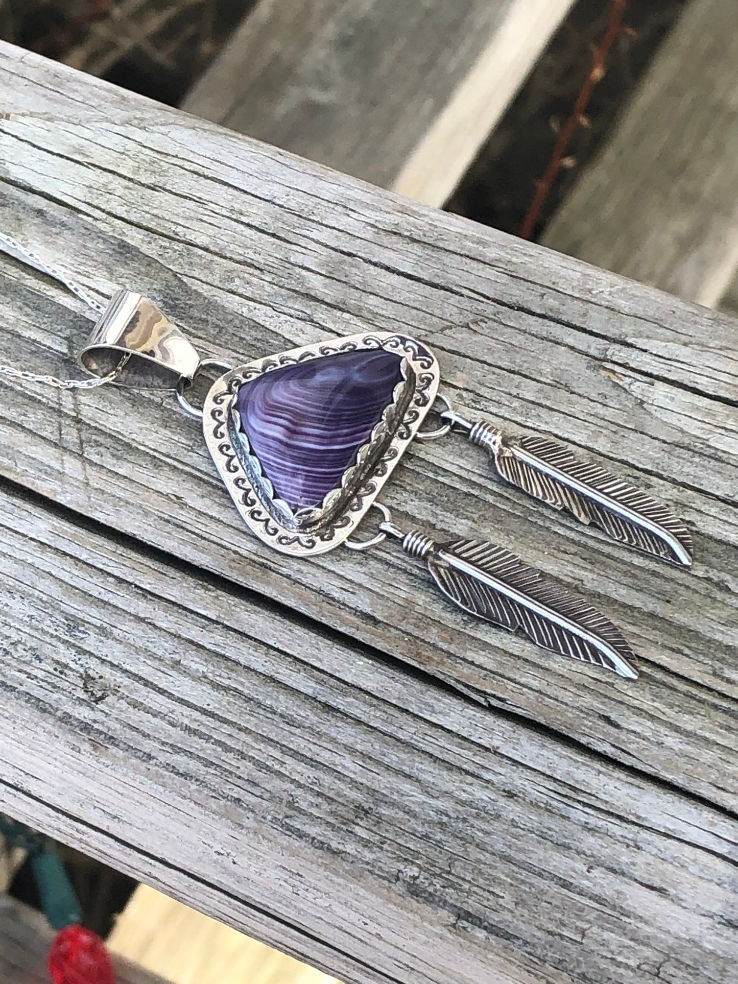 Wampum pendant with feathers.