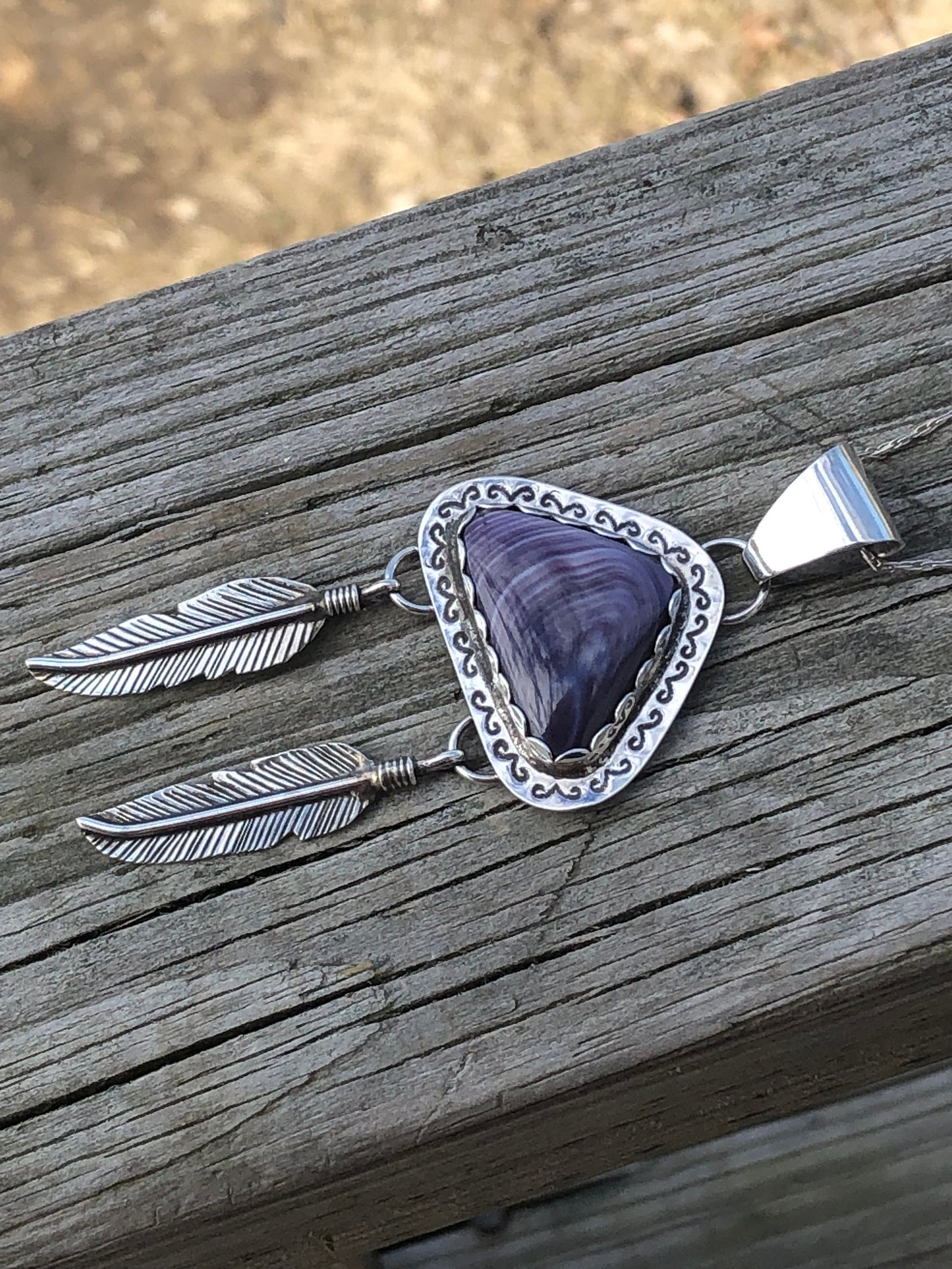 Wampum pendant with feathers.