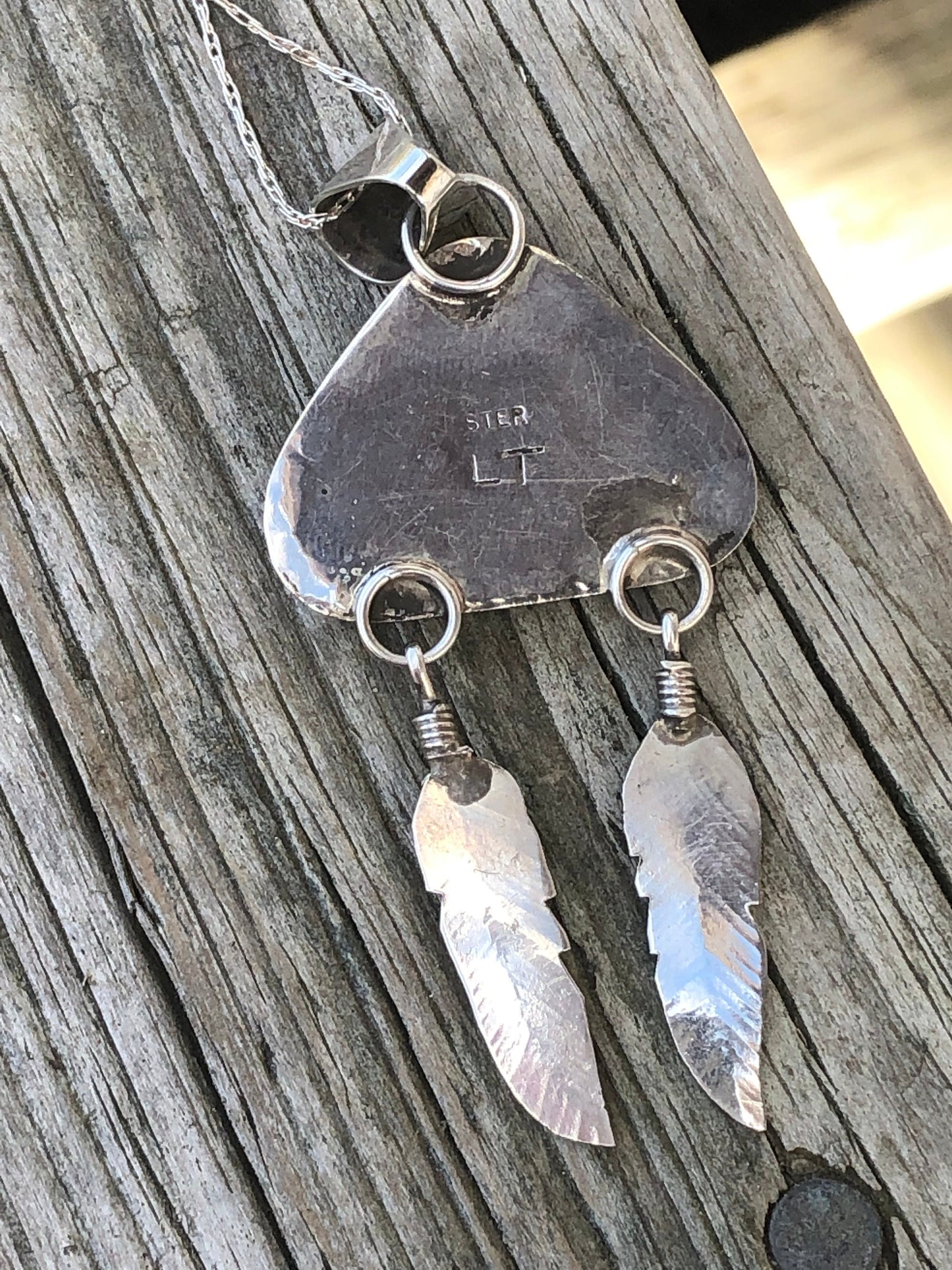 Wampum pendant with feathers.